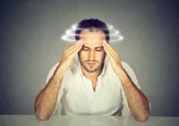 A man sits while dealing with hangover circles and spins